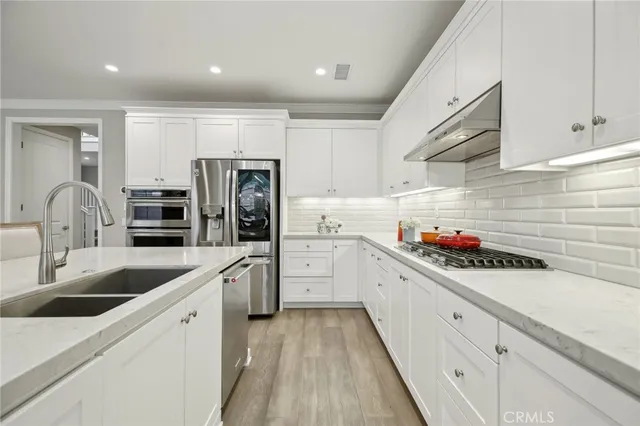 a kitchen with white cabinets and sink