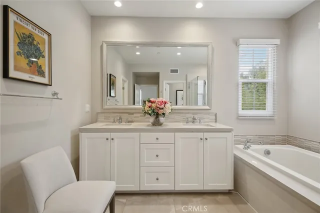 a bathroom with a granite countertop sink mirror bathtub and toilet