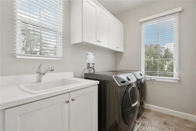 a utility room with sink dryer and washer