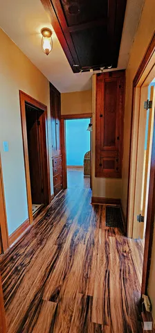 a hallway with wooden floor and furniture