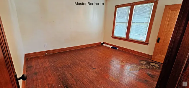a view of a hallway with wooden floor and a window