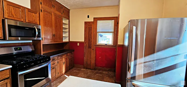 a kitchen with stainless steel appliances granite countertop a refrigerator and a stove top oven