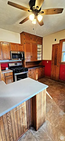 a kitchen with wooden cabinets and a stove