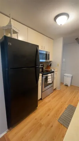 a kitchen with stainless steel appliances granite countertop a sink a stove and white cabinets