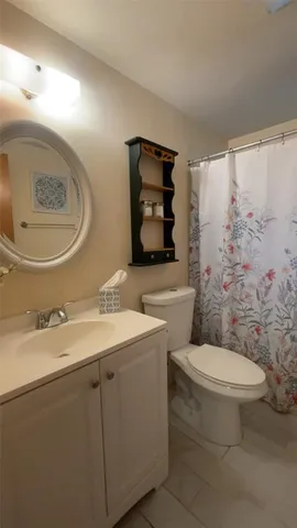 a bathroom with a toilet and a shower curtain