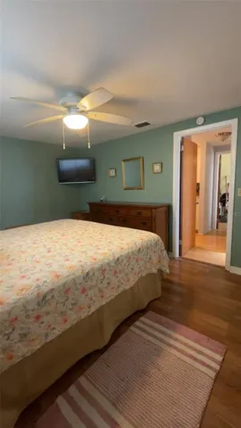 a spacious bedroom with a bed and a mirror on dresser