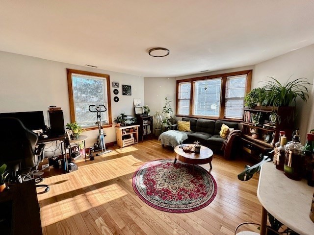 144 Robbins Street, Unit 4 Waltham, MA 02453 - Photo 1 of 8 a living room with furniture a rug and a large window