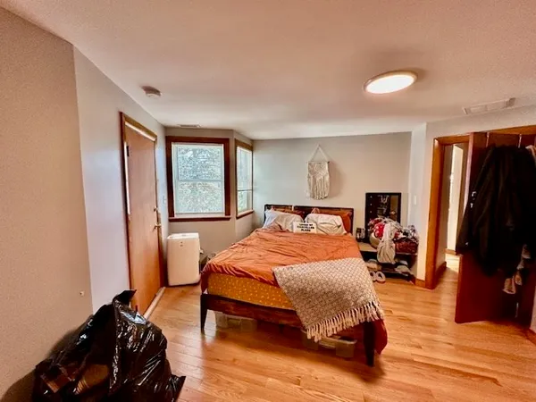 a bedroom with a bed and wooden floor