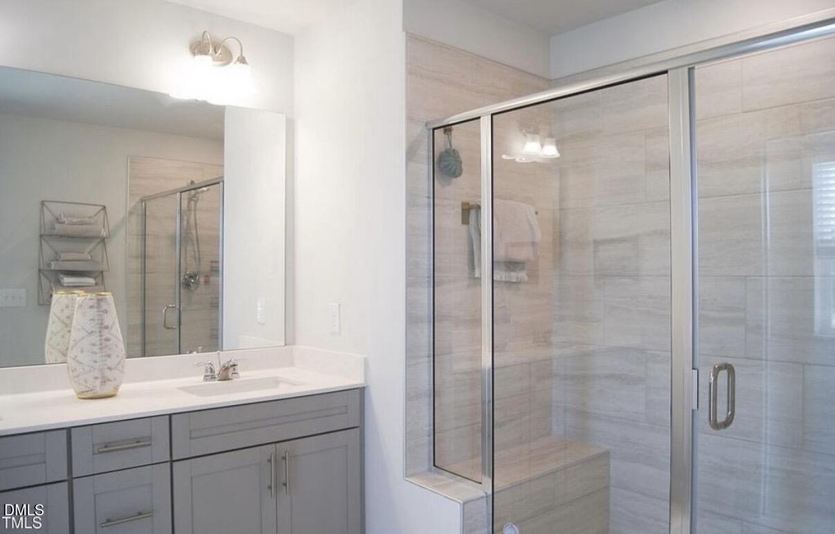 5006 Tura Street Raleigh, NC 27610 - Photo 19 of 32 a bathroom with a shower sink and mirror