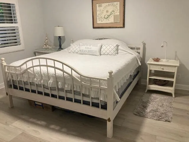 a large white bed sitting in a bedroom next to a window