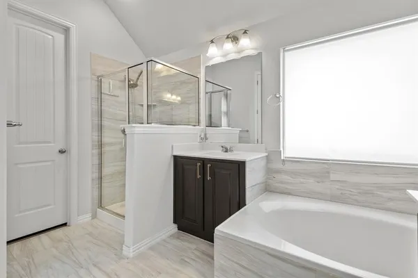 a spacious bathroom with a bathtub sink and mirror
