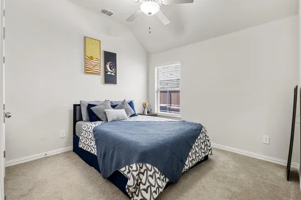 a bedroom with a bed lamp and a window