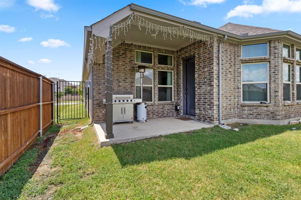 448 LeTara Ranch Drive Haslet, TX 76052 - Photo 26 of 32 a view of a house with brick walls and a yard with a large tree