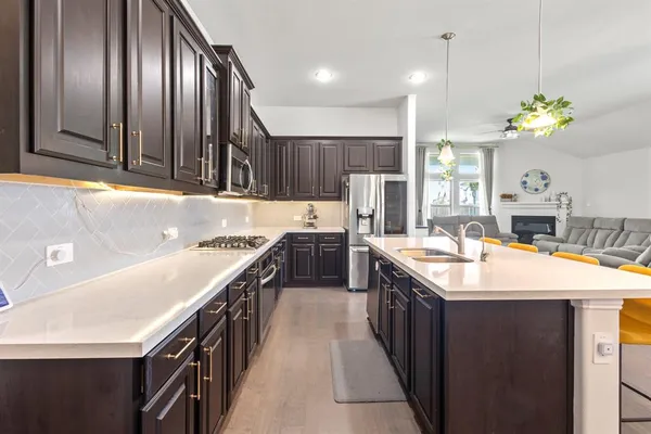 a kitchen with kitchen island granite countertop stainless steel appliances a sink stove and cabinets
