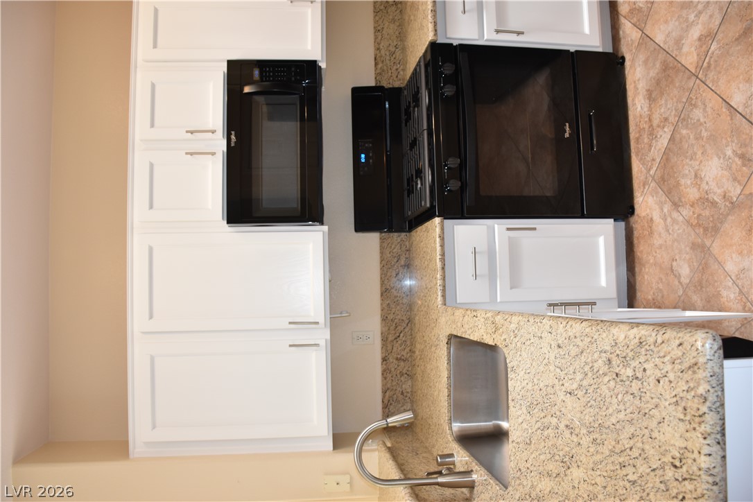1680 Fieldbrook Street Henderson, NV 89052 - Photo 5 of 32 Richly patterned stone countertops harmonize beautifully with classic white cabinetry and tile floors.