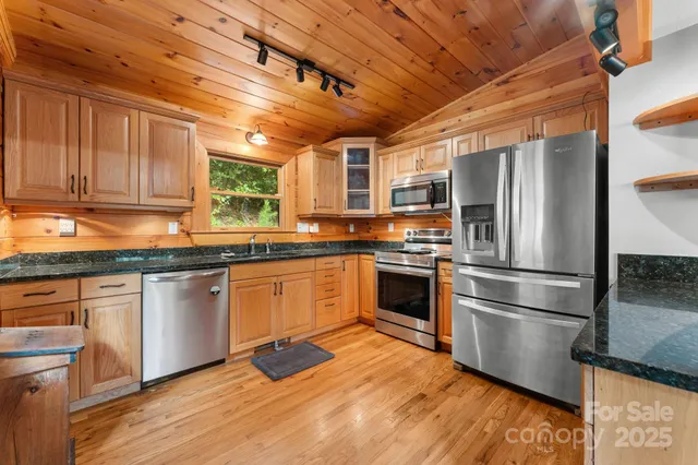 a kitchen with granite countertop stainless steel appliances and wooden cabinets
