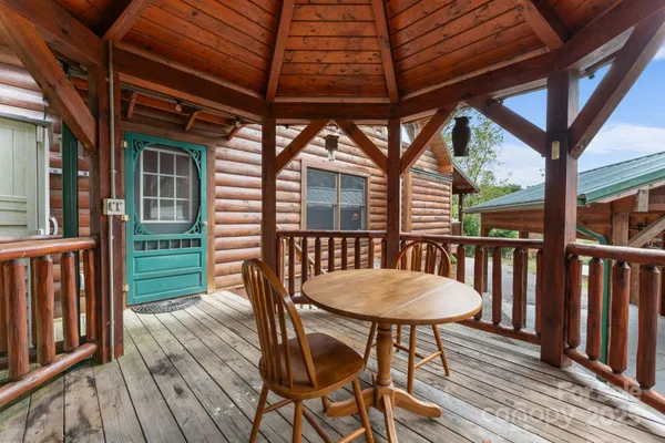 a view of a wooden table and chairs in the balcony