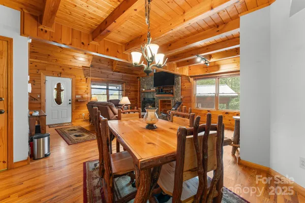 a dining room with furniture a chandelier and wooden floor