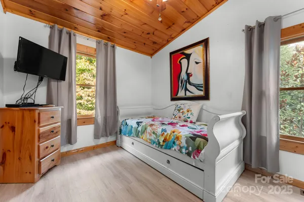 a bedroom with a bed and painting on the wall