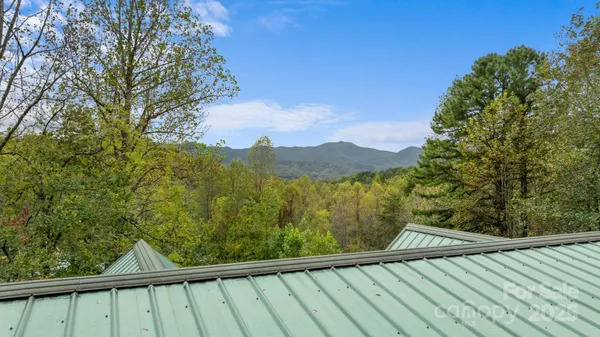 a front view of a house with a garden and trees