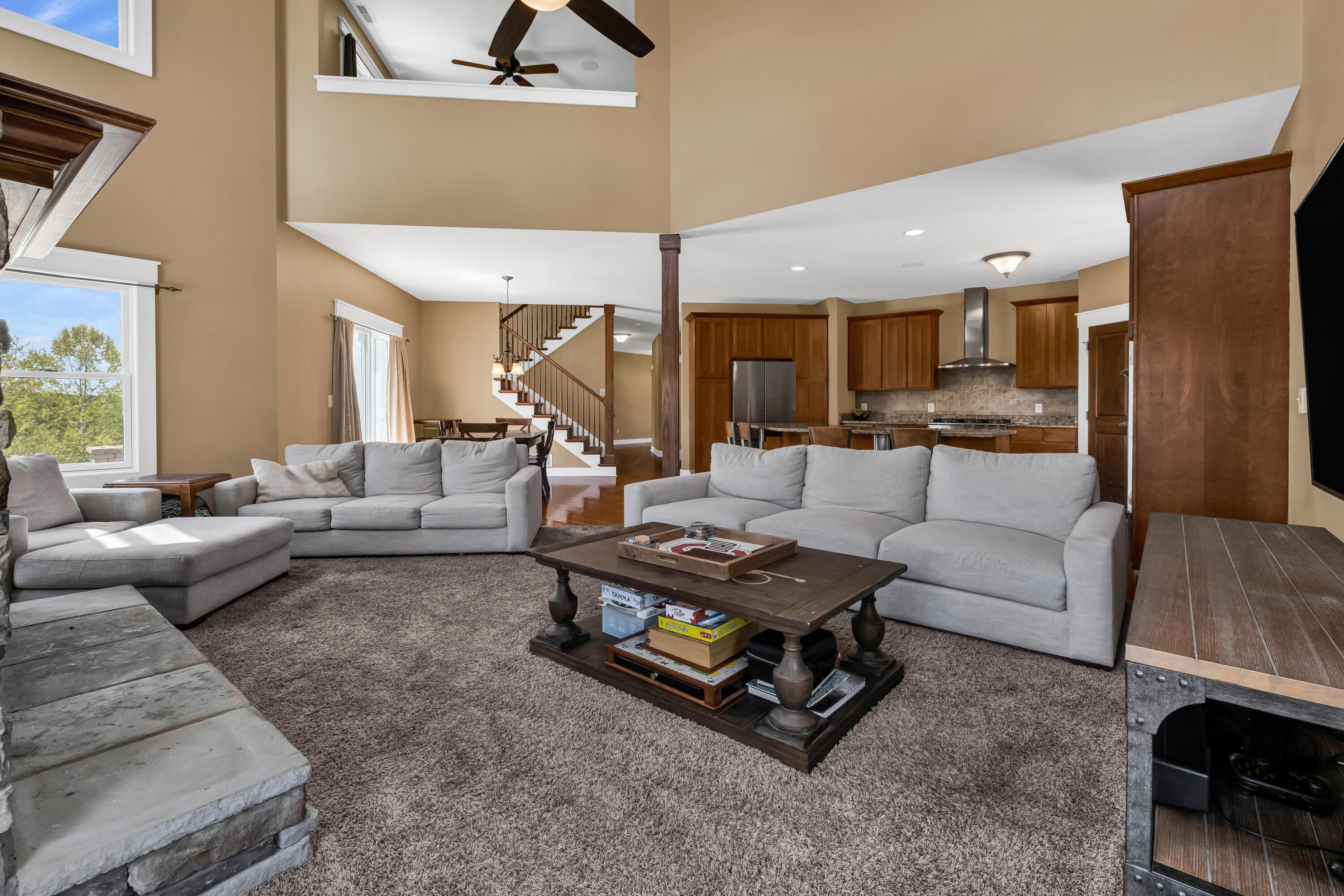 16689 Bailor Road Laurelville, OH 43135 - Photo 27 of 73 • Light sand carpet
• Tan painted walls
• Two story ceiling
• New lighted ceiling
fan ~ 2025
• Stone floor to ceiling,
woodburning fireplace
with raised hearth &
mantle
