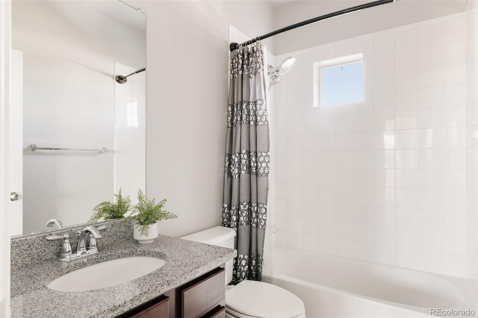 5191 Willow Way Denver, CO 80238 - Photo 22 of 36 a bathroom with a granite countertop sink toilet and shower