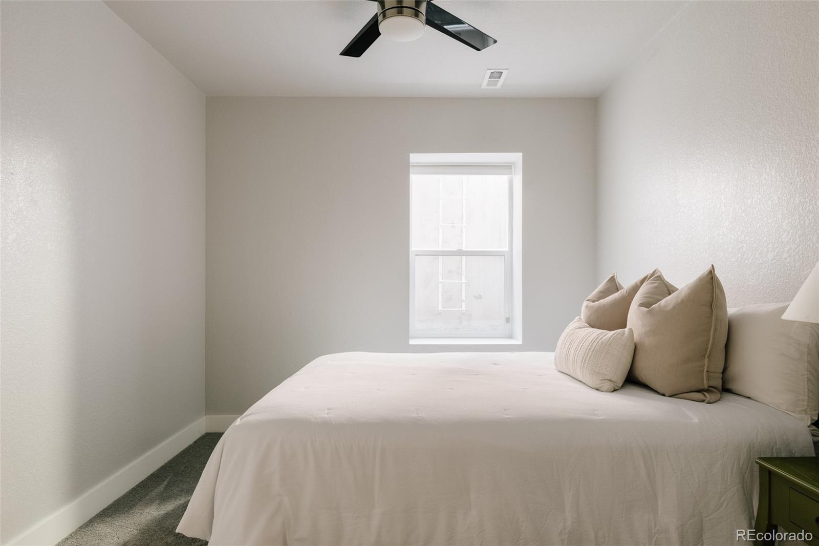 5191 Willow Way Denver, CO 80238 - Photo 26 of 36 a bedroom with a bed and a window