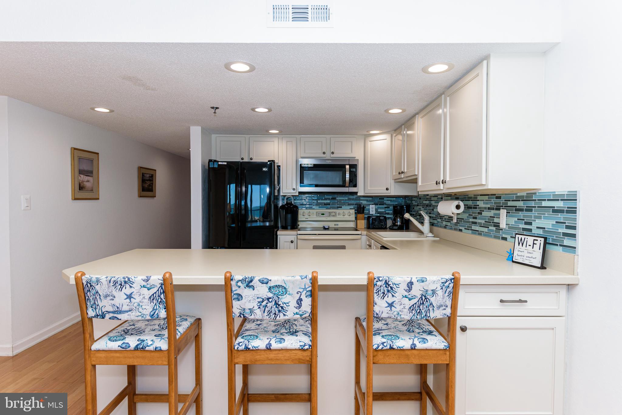 5 77th Street, Unit 102 Ocean City, MD 21842 - Photo 3 of 38 a kitchen with stainless steel appliances granite countertop a refrigerator and microwave