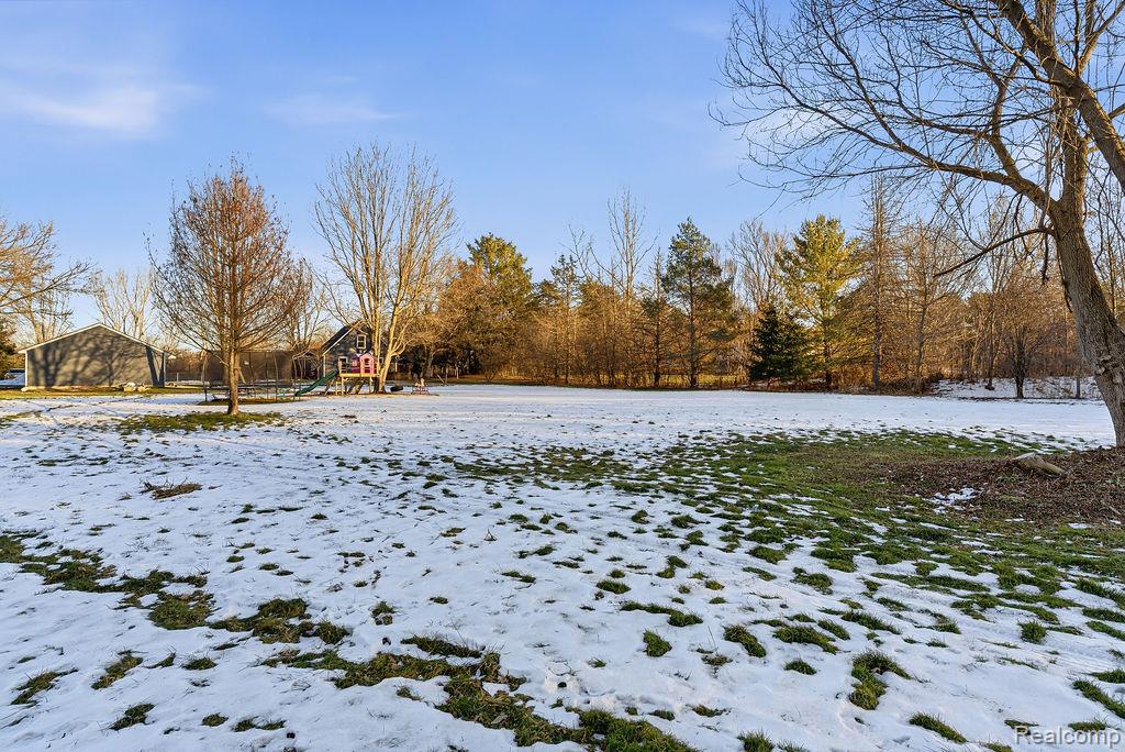 5216 South State Road Goodrich, MI 48438 - Photo 35 of 52 Yard covered in snow featuring a playground