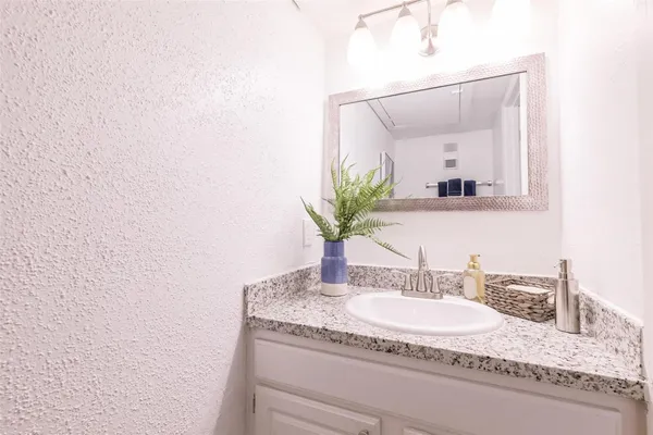 a bathroom with a granite countertop sink and a mirror