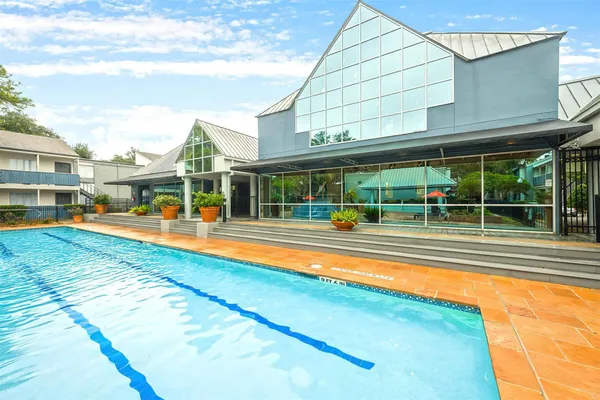 a view of a swimming pool with a patio and a yard