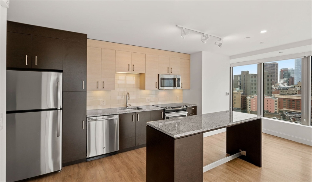 99 Kneeland Street, Unit 1901 Boston, MA 02111 - Photo 5 of 18 a kitchen with stainless steel appliances granite countertop a refrigerator a sink and a stove