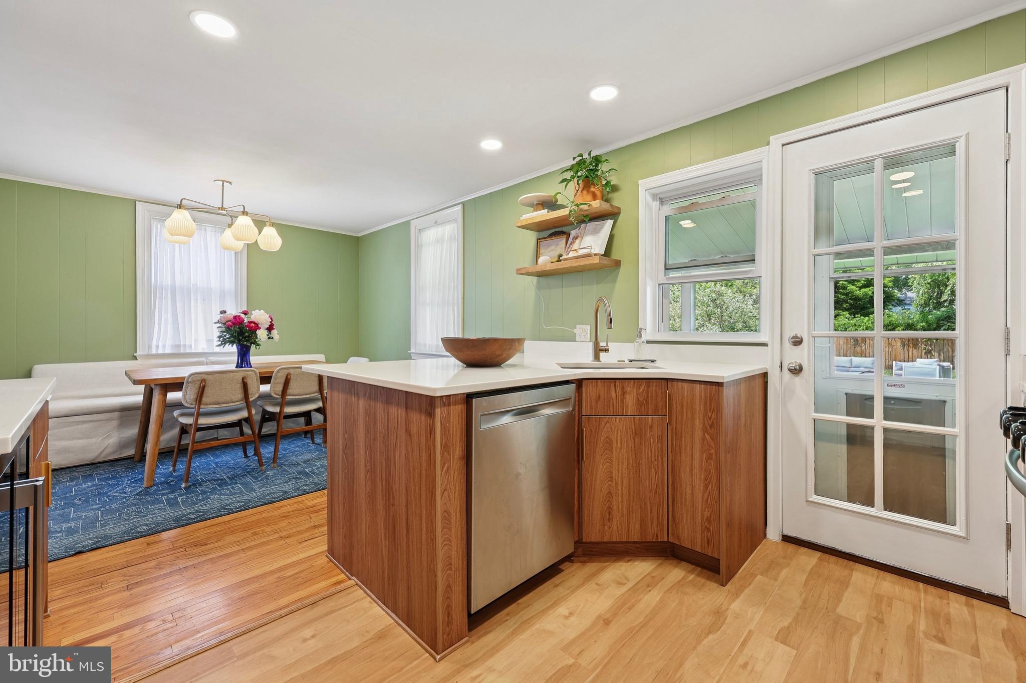 7808 Ridge Avenue Philadelphia, PA 19128 - Photo 7 of 18 a open kitchen with stainless steel appliances granite countertop a refrigerator a sink a dining table and chairs with wooden floor