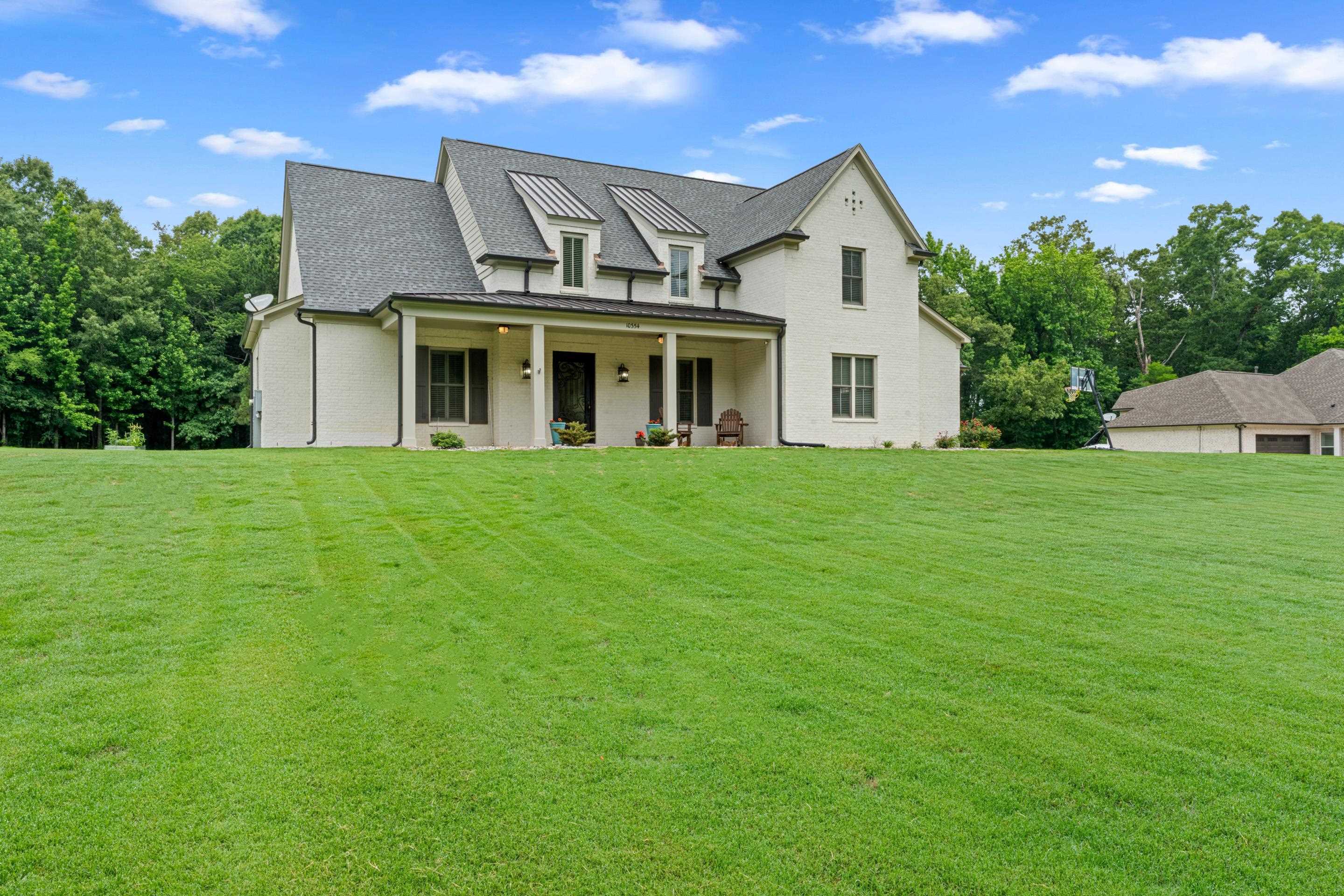 10354 Pleasant Ridge Road Arlington, TN 38002 - Photo 34 of 40 Elegant painted brick exterior with welcoming front porch, manicured landscaping, and an impressive oversized yard that creates a private, retreat-like setting.