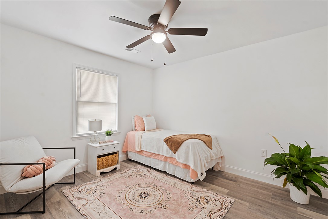 701 Quarry Street Anderson, SC 29624 - Photo 8 of 16 A well-lit bedroom provides a serene escape, complete with stylish flooring and a functional ceiling fan for comfort.