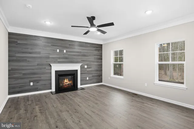 an empty room with windows and a fireplace