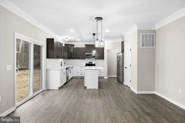 a kitchen with a sink stainless steel appliances a counter space and cabinets