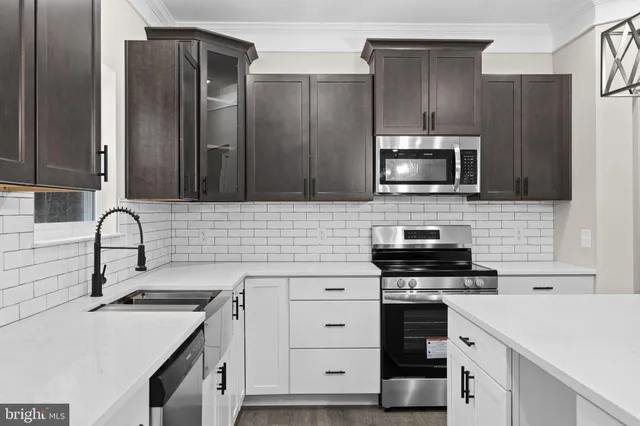 a kitchen with stainless steel appliances a sink stove and cabinets