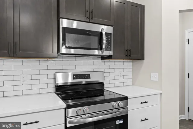 a kitchen with stainless steel appliances a stove sink and microwave