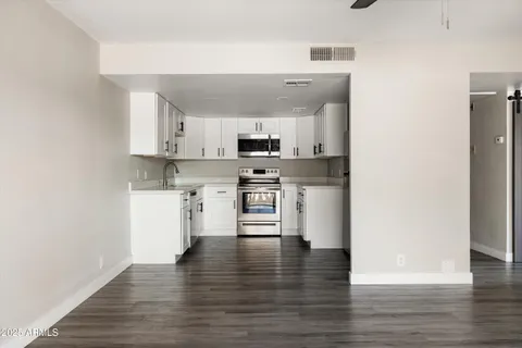 a view of kitchen with sink microwave and cabinets