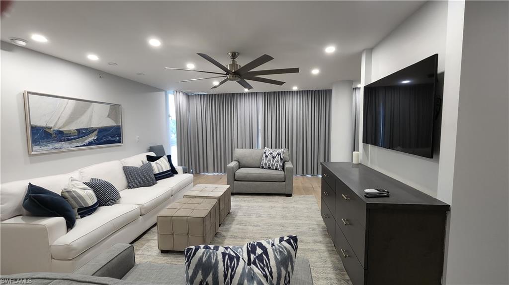 20 Seagate Drive, Unit 301 Naples, FL 34103 - Photo 18 of 29 a living room with furniture and a flat screen tv