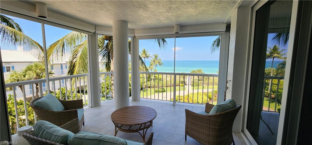 20 Seagate Drive, Unit 301 Naples, FL 34103 - Photo 25 of 29 a living room with furniture and a large window