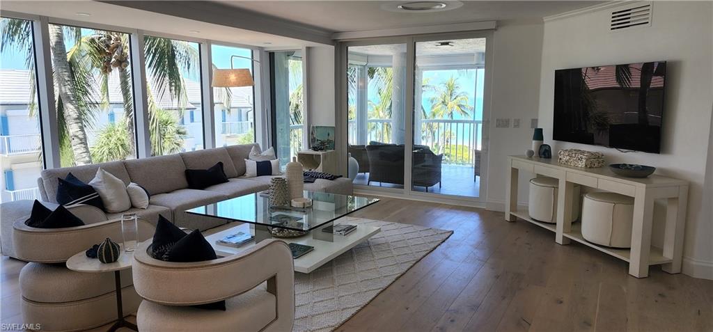 20 Seagate Drive, Unit 301 Naples, FL 34103 - Photo 4 of 29 a living room with furniture and a flat screen tv
