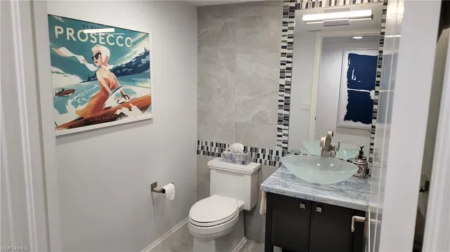 a bathroom with a granite countertop sink and a toilet