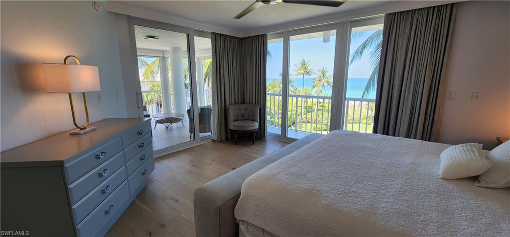 20 Seagate Drive, Unit 301 Naples, FL 34103 - Photo 10 of 29 a spacious bedroom with a bed and a lamp on table next to a window