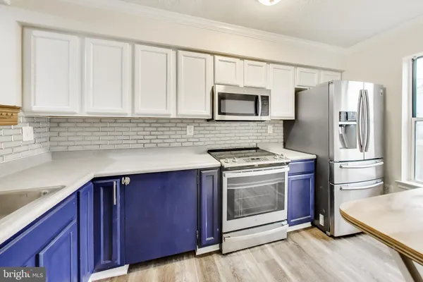 a kitchen with granite countertop a stove microwave and refrigerator