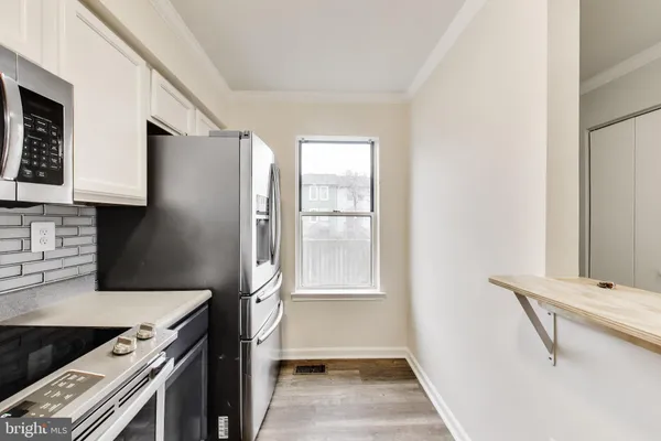 a kitchen with a refrigerator and a stove top oven