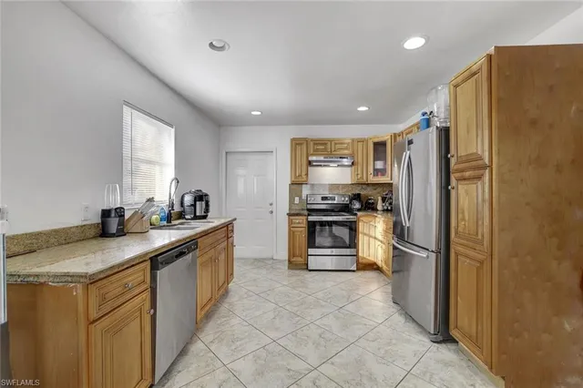 a kitchen with a refrigerator sink and stove