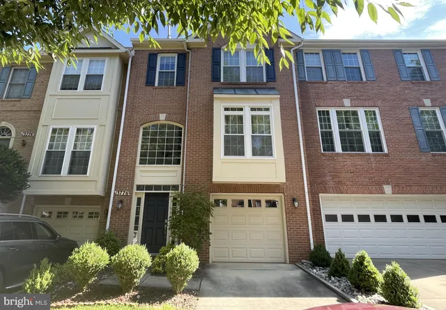 a front view of a building with a garden and plants