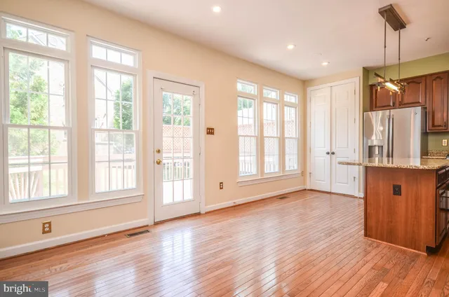 a kitchen with stainless steel appliances granite countertop a refrigerator a sink dishwasher a stove with wooden floor and cabinets